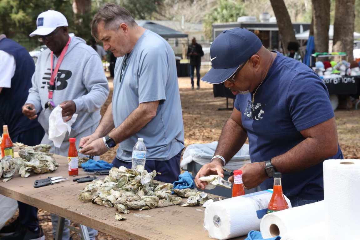 People shucking oysters at the Gullah Oyster Festival